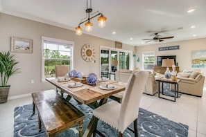 A dining area with a wooden table, chairs, and a clock on the wall.