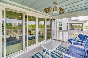 A covered porch with a white railing, large glass doors, and blue outdoor furniture. - Paradise Found at Lost Key Resort: Tropical Bliss (Pensacola)