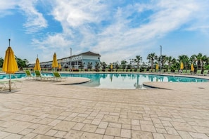 A swimming pool with lounge chairs and yellow umbrellas, surrounded by palm trees and a building in the background. - Paradise Found at Lost Key Resort: Tropical Bliss (Pensacola)