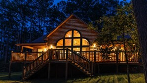 A wooden cabin with a balcony and a staircase leading to the entrance. - Juniper Haven | 2BR + Loft, Hot Tub & Pets (Broken Bow)