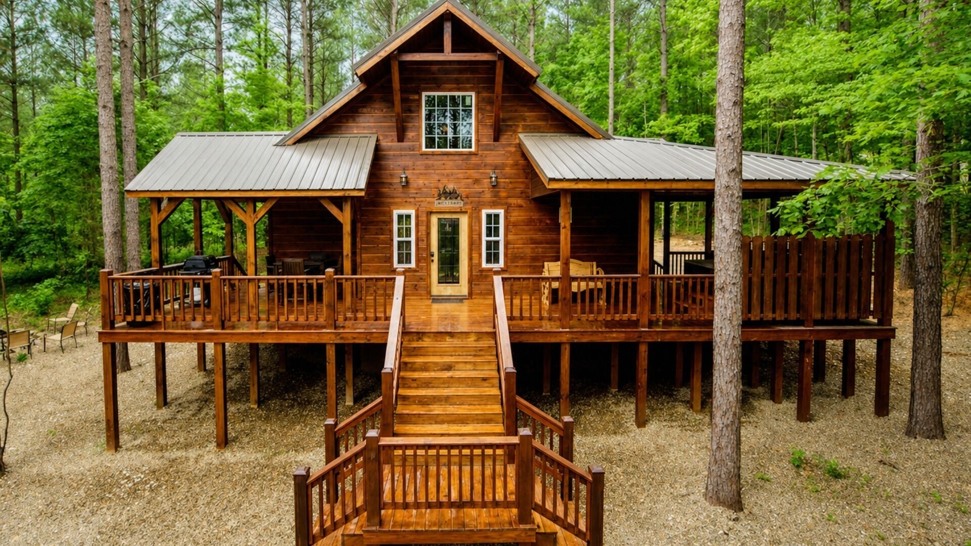 Una cabaña de madera con entrada central, un porche cubierto y una terraza con barandillas.