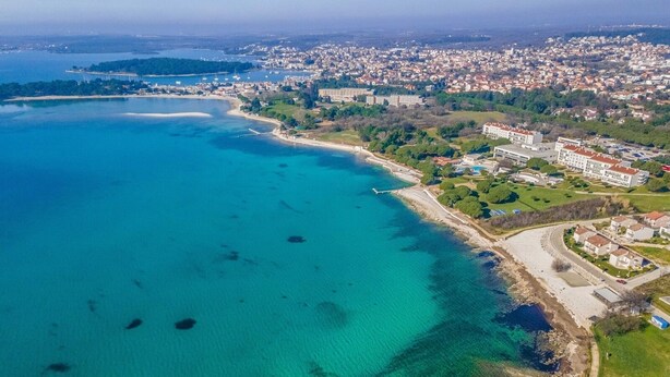 An aerial view of a coastal town with a beach, residential buildings, and a marina. - Holiday Home in Medulin with Seaview, Terrace, Air condition, WIFI (3486-4) (Medulin)