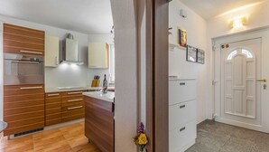 A modern kitchen with wooden cabinets, a built-in oven, and a white refrigerator. - Holiday Home in Medulin with Seaview, Terrace, Air condition, WIFI (3486-4) (Medulin)