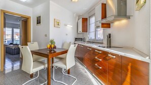 A modern kitchen with a wooden island, white cabinets, and a built-in microwave. - Holiday Home in Medulin with Seaview, Terrace, Air condition, WIFI (3486-4) (Medulin)