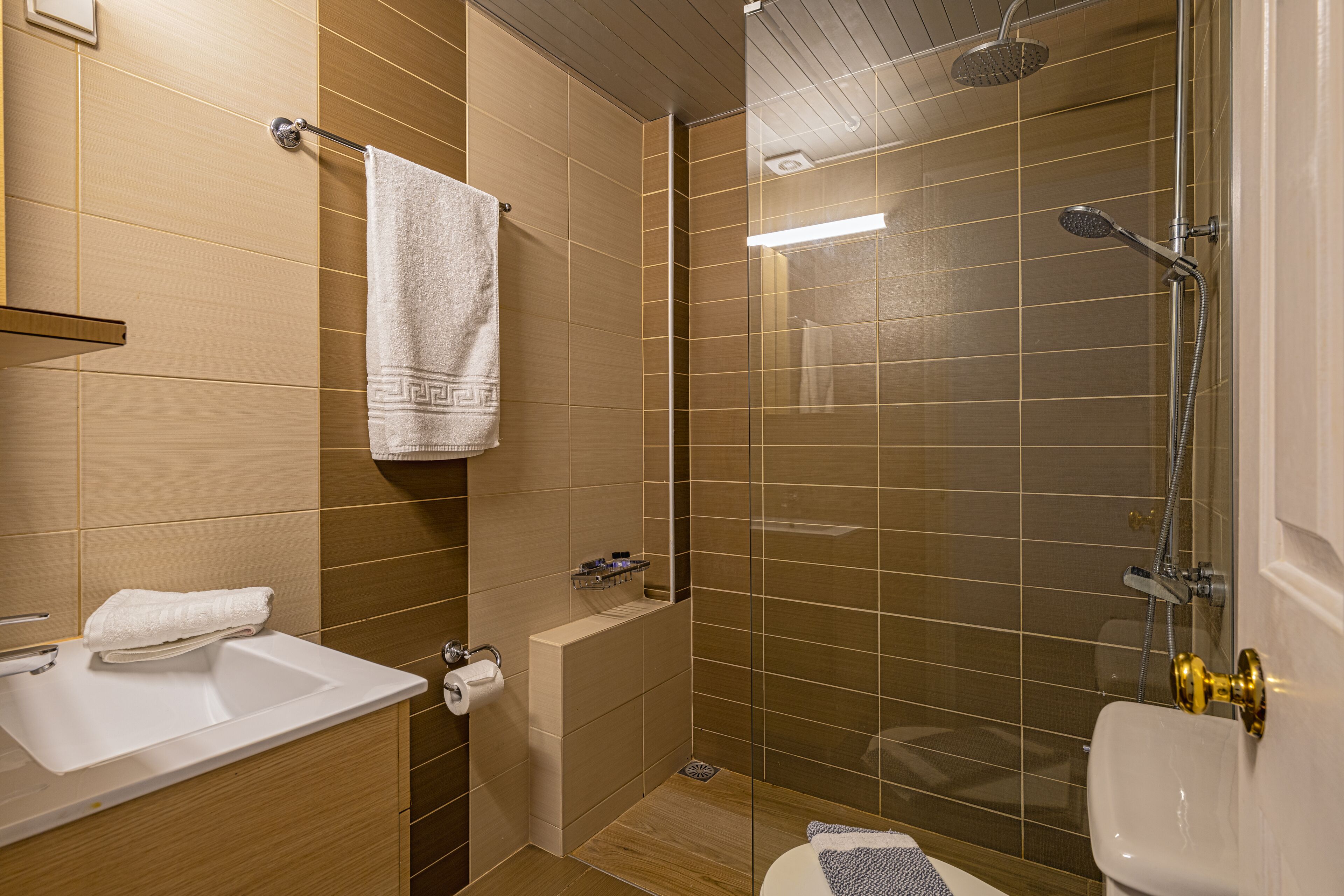 Ein modernes Badezimmer mit Waschbecken, Toilette und Duschbereich.