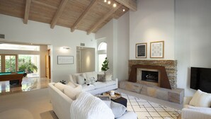 A spacious living room with a high ceiling, a fireplace, a pool table, and a comfortable seating area. - 30 Days+ at a Palm Springs Oasis (Palm Springs)