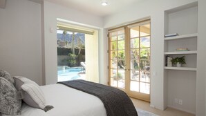 A bedroom with a bed, a large window, and a view of a pool and mountains. - 30 Days+ at a Palm Springs Oasis (Palm Springs)