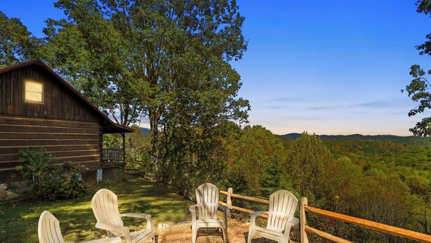 A rustic cabin with a fire pit and Adirondack chairs in a forested area. - Stunning Mountain Views!!! Secluded Log Cabin with Hot Tub near West Jefferson  (Lansing)