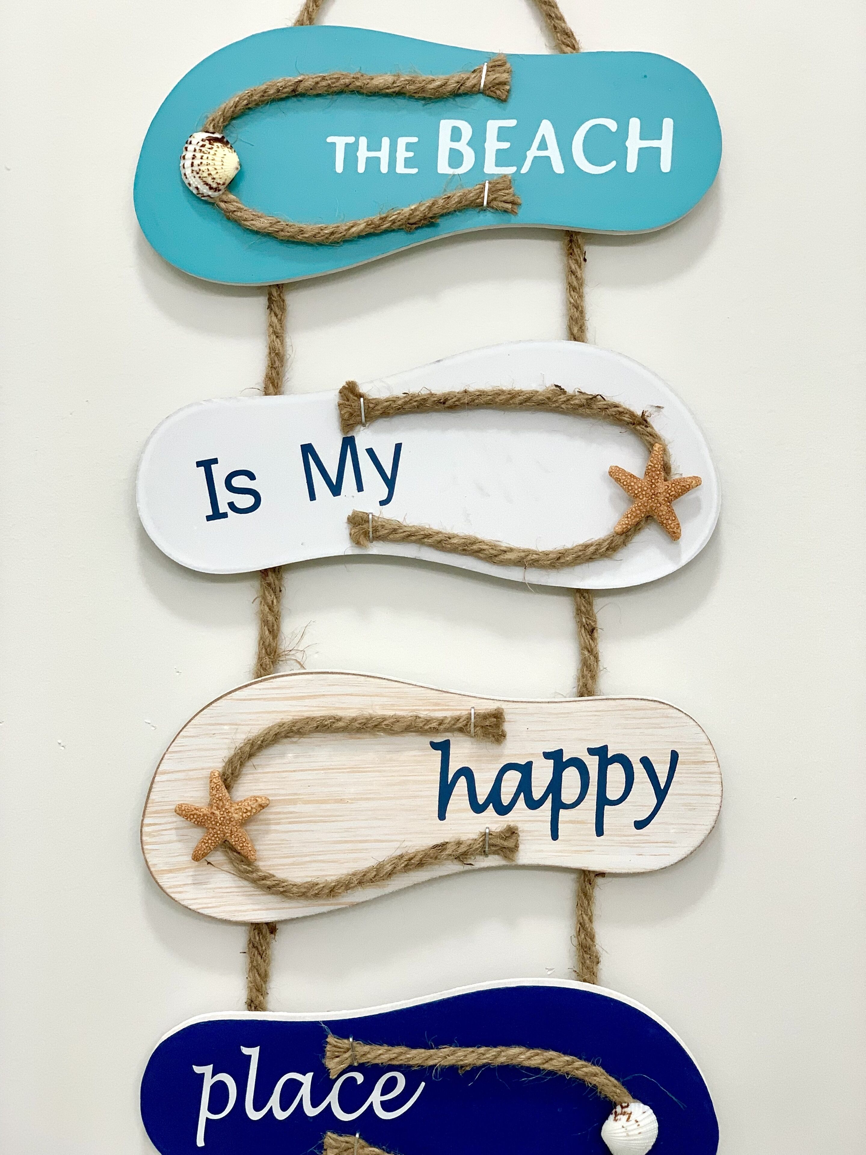 Un panneau décoratif avec l’inscription « La plage est mon endroit préféré » et des motifs d’étoiles de mer.