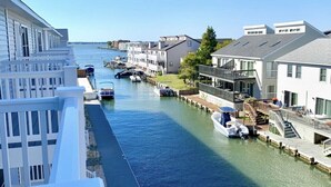 A canal with boats, waterfront buildings, and a dock. - IslandCoveParadise: Luxury-NewlyBuiltTH! OnTheWater-Boardwalk-Pool-w/2 CarGarage (Ocean City)