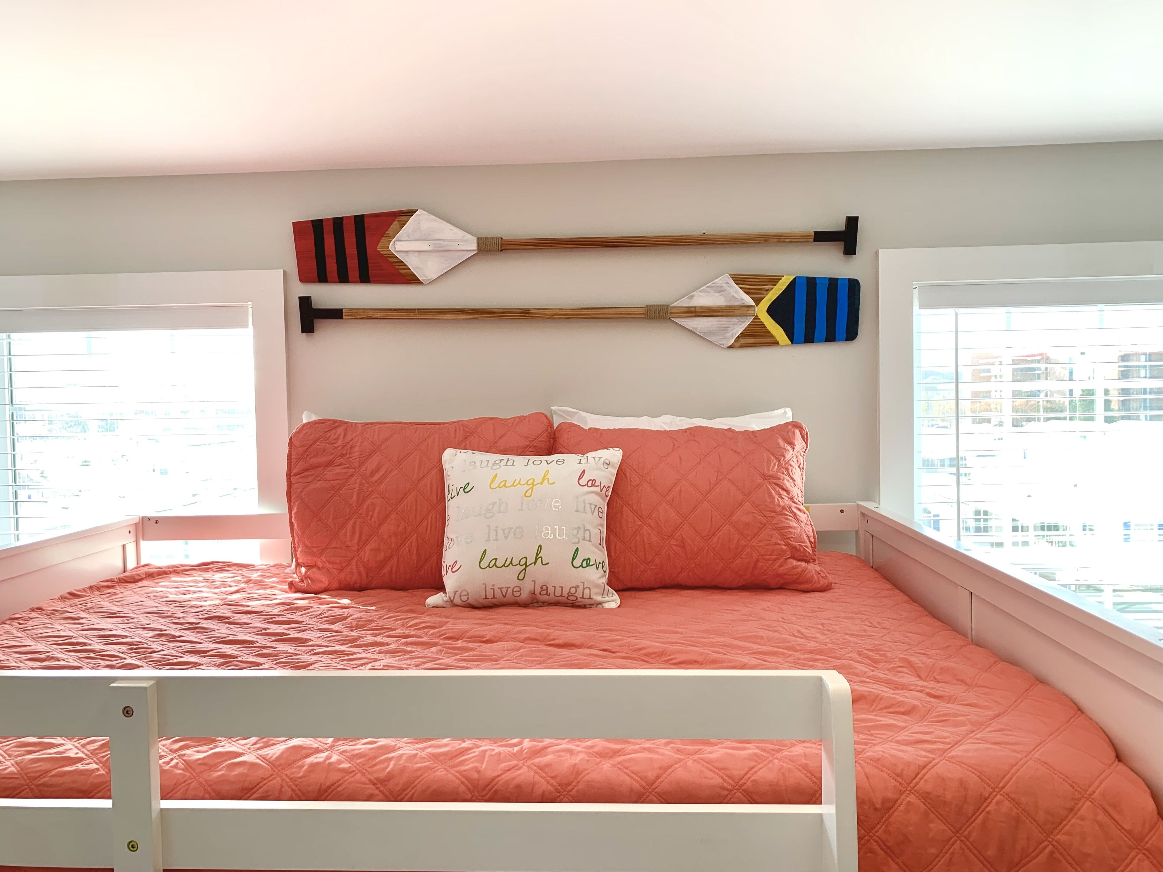 Ein Schlafzimmer mit einem Bett, Kissen und zwei dekorativen Schlägern an der Wand.