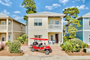 A two-story building with a covered porch and a golf cart parked in front.