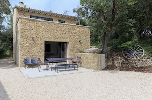 Un edificio de piedra con un patio que tiene una mesa y sillas.