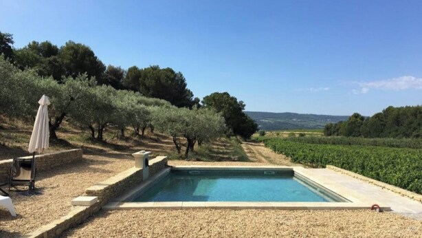 A rectangular pool with stone edging, surrounded by a gravel area.