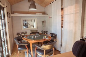 A dining area with a round wooden table, six chairs, and a mirror above the table.