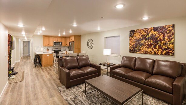 A modern living room with a brown leather sofa, a wooden coffee table, and a patterned rug. - Gorgeous brand new 2BR unit, sleeps 6.  Amazing ski location! (Salt Lake City)