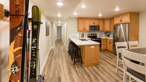 A modern kitchen with wooden cabinets, stainless steel appliances, and a central island with bar stools. - Gorgeous brand new 2BR unit, sleeps 6.  Amazing ski location! (Salt Lake City)