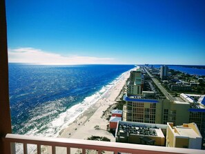 Eine Küstenstadt mit Strand, Gebäuden und blauem Himmel.