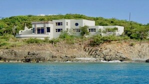A coastal building with a modern architectural style, situated on a rocky hillside with a view of the sea. - Winter Waterfront, amazing views of the Caribbean Seas. (St Thomas)