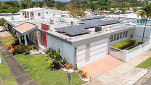 Un bâtiment moderne doté d’un toit plat, de panneaux solaires et d’un garage.