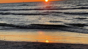 A sunset over the ocean with waves approaching the shore. - Davenport Disney-Area Home ~ Private Pool & Hot Tub ~ Quiet Retreat (Davenport)