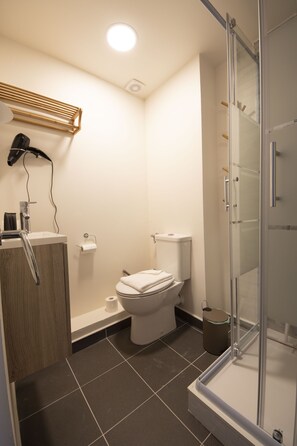Een douche, een haardroger, handdoeken, toiletpapier