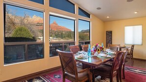 Un comedor con un amplio ventanal que da a un paisaje montañoso.