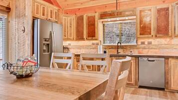 A wooden kitchen with a refrigerator, sink, and dishwasher.