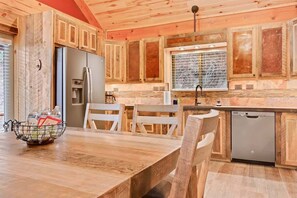 A wooden kitchen with a refrigerator, sink, and dishwasher.