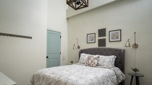 A bedroom with a bed, a door, and wall-mounted decor.