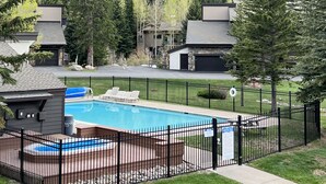 A residential area with a swimming pool, a fenced deck, and houses with stone facades. - Newly Renovated, 3 bd, 3 bath on shuttle route (Vail)