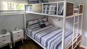 A bunk bed room with a window, a desk, and a nightstand. - Relax at Moon Dogs Getaway! (Erie)