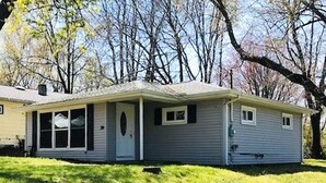 A single-story house with a front porch, a garage, and a small attached shed. - Relax at Moon Dogs Getaway! (Erie)