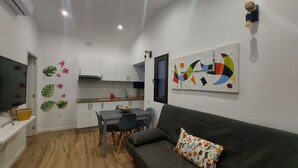 A compact living space with a kitchenette, a dining area, and a sofa.