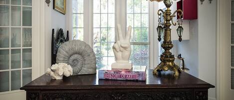 A dark wooden table with a book titled "History of Art," a white sculpture, and a gold and black lamp.