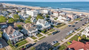 Une zone résidentielle côtière avec des maisons, une plage et un ciel dégagé.