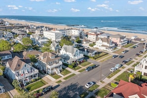 A coastal residential area with houses, a beach, and a clear sky. - 4 HOUSES to BEACH! Remodeled 2026. 4 passes, chairs, towels, umbrellas included (Belmar)