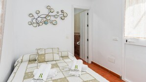 Une chambre à coucher avec un lit, un élément décoratif mural, une porte et une fenêtre.
