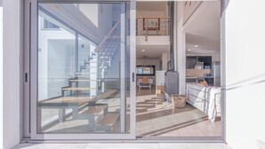 Un interior moderno con una escalera que sube a un segundo piso, un comedor y una cocina.