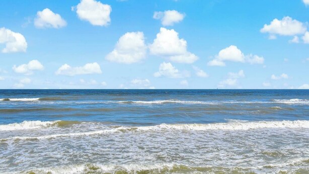 Una playa con olas y cielo despejado.