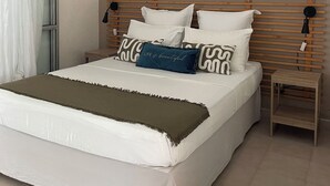 Een keurig opgemaakt slaapkamer met een bed, nachtkastjes en kunstwerken aan de muur.