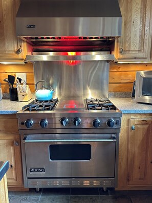 Kitchen equipped with a gas range stove, wooden cabinetry, and granite countertop.