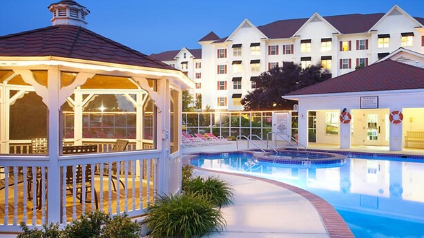 A swimming pool with lounge chairs and a gazebo.