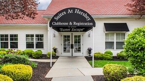 A building with a sign reading "Suites At Hershey Clubhouse & Registration" and a slogan "Sweet Escape".