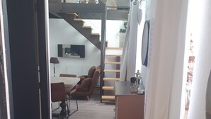 Un intérieur moderne comprenant un escalier, un coin salon et un bureau.