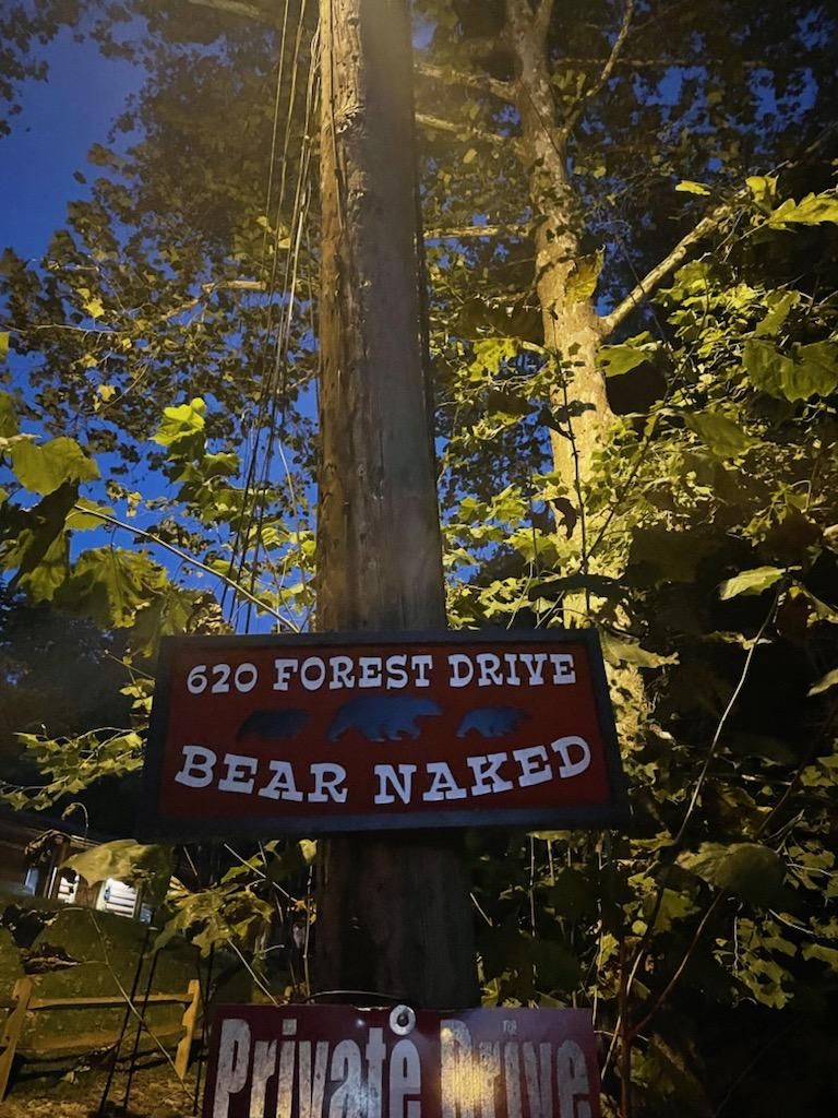 A sign on a telephone pole that reads "620 Forest Drive Bear Naked Private Drive."