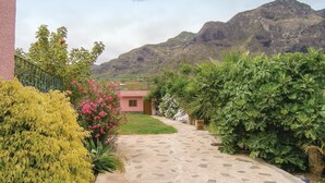 A paved pathway leading to a building with a mountain backdrop. - 1 bedroom amazing apartment in Buenavista Del Norte (Buenavista Del Norte)