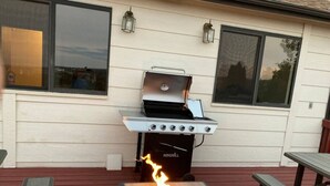 A barbecue grill with a fire pit in front, set on a wooden deck with picnic tables. - 5BR Recently Updated Retreat w/ Hot Tub, BBQ grill, Fire Pit, Near Attractions (Colorado Springs)