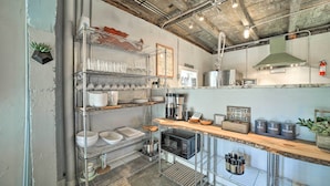 A kitchen with metal shelves, a coffee machine, and a microwave. - Eclectic Asheville Abode w/ Backyard Oasis! (Asheville)