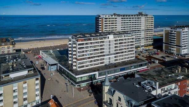 A multi-story hotel with a modern architectural design, located near a beach with a view of the ocean. - Art your Life - Residence, Whg. 11 Superdet - Art your Life - Residence Seeburg (Sylt)
